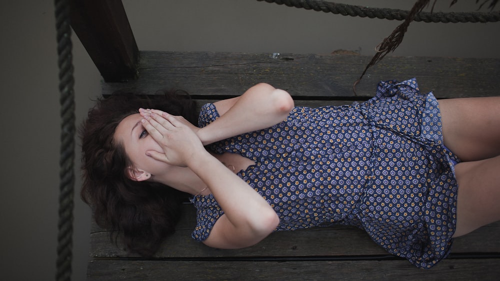 a woman laying down on a wooden bench
