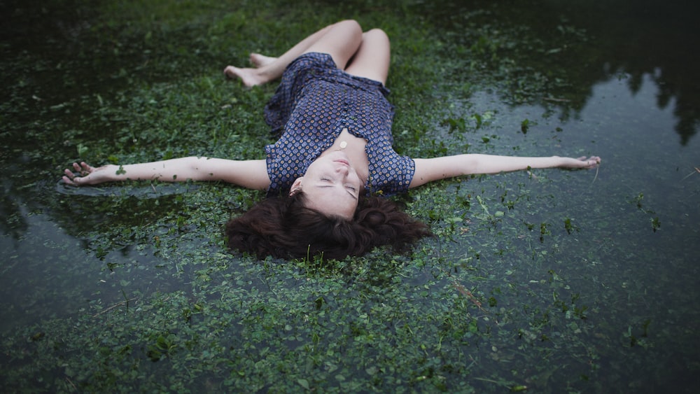 a woman laying on the ground in the water