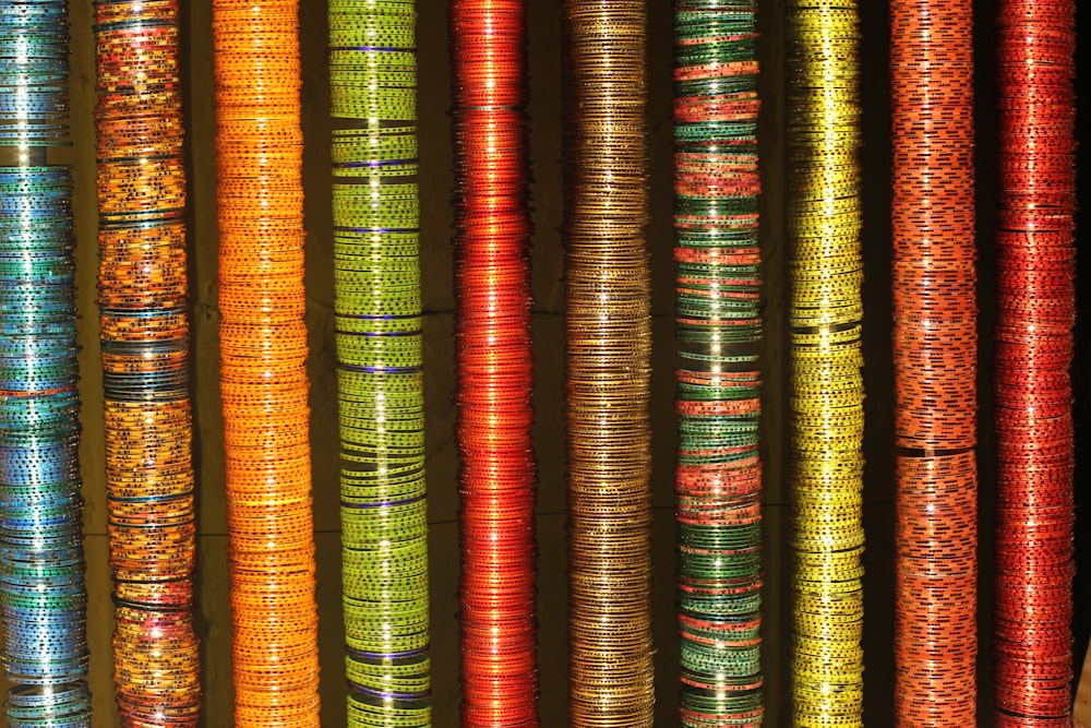 um monte de pulseiras de cores diferentes penduradas em uma parede