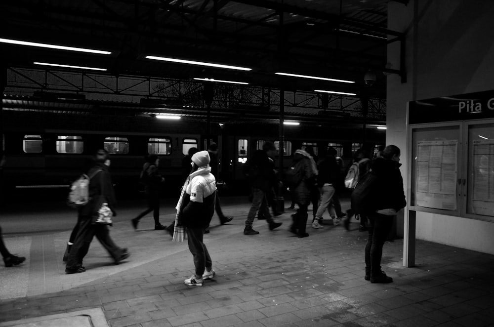 Eine Gruppe von Menschen, die um einen Bahnhof herumlaufen