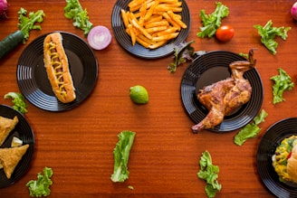 A vibrant spread of burgers, pizzas, and fries on a wooden table.