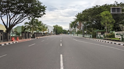 Wide road cutting through the plot area with clear signage and greenery on both sides.