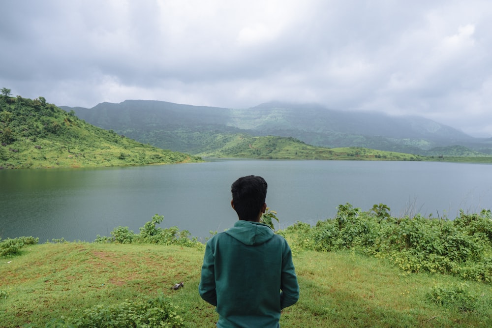 a man standing on top of a lush green hillside