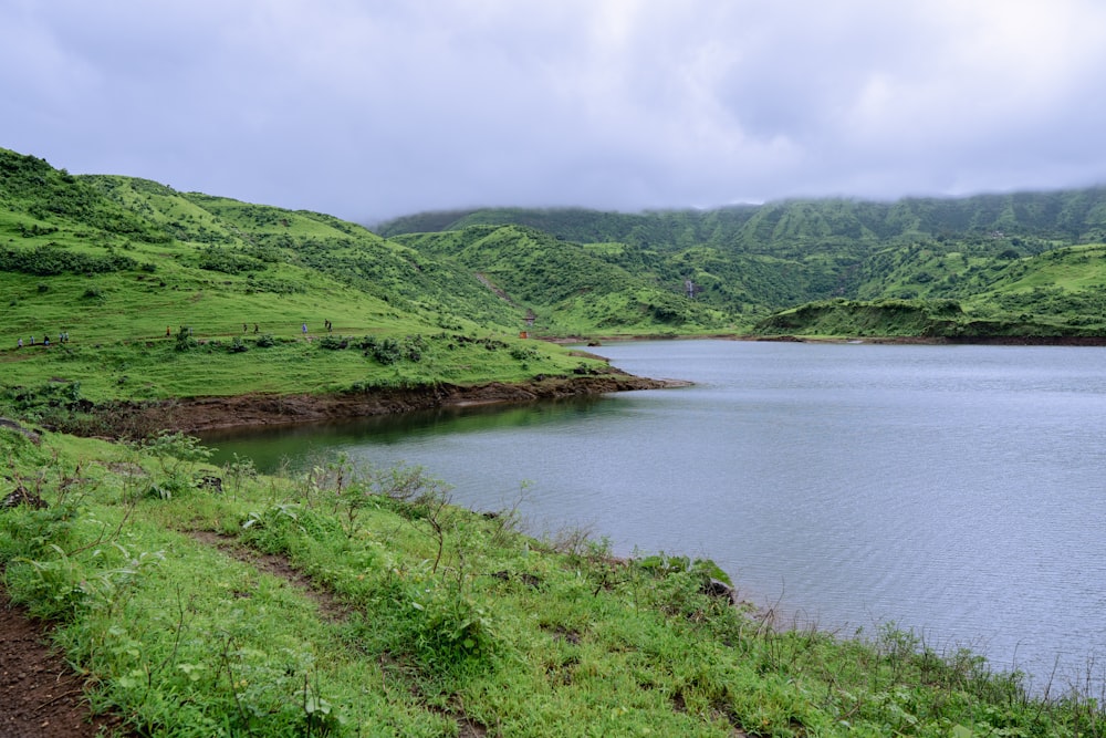 a large body of water surrounded by lush green hills