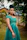 Elegant woman in a floral dress from twelve28, posing outdoors with greenery in the background.