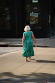 a woman in a green dress walking down the street