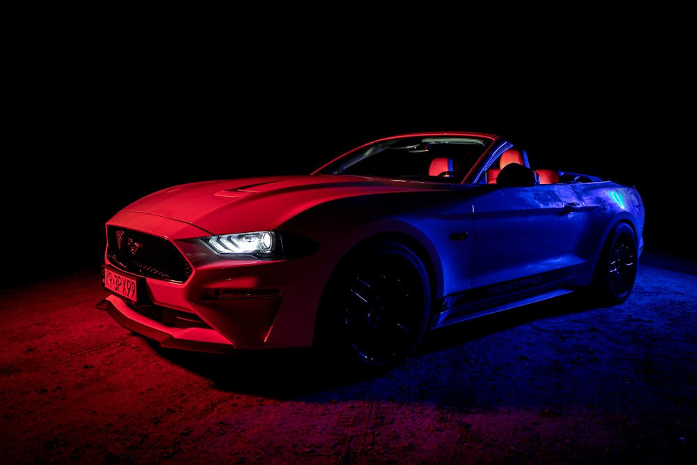 a red and blue mustang in the dark