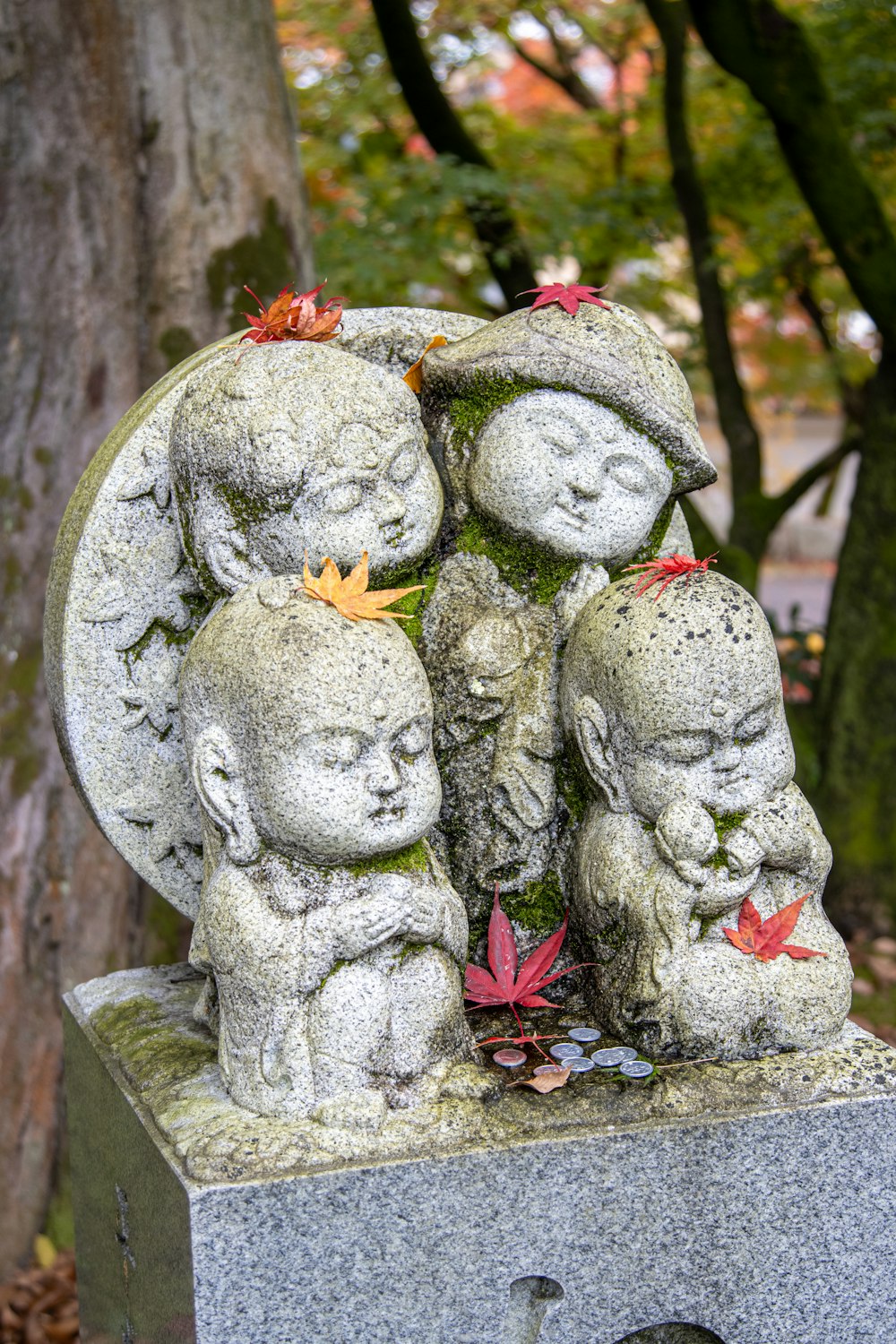 a group of statues sitting next to a tree