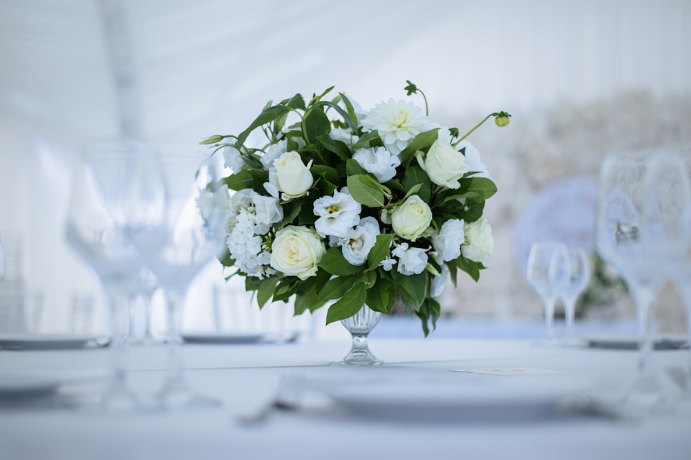 eine Vase gefüllt mit weißen Blumen auf einem Tisch