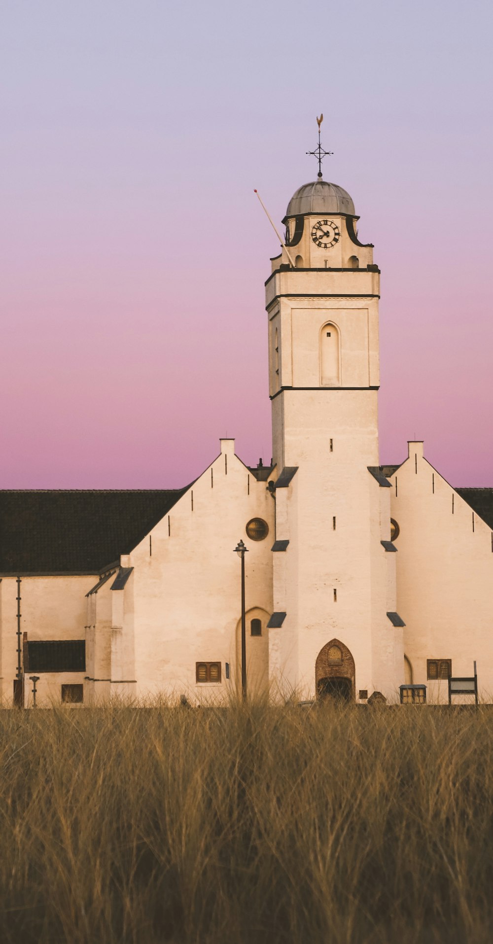 a tall white building with a clock tower