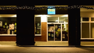 A vibrant storefront sign illuminated at dusk.