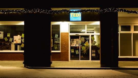 Brightly lit custom business sign mounted on a storefront at night.