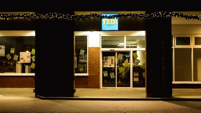 A storefront sign illuminated at night.