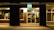 A modern storefront illuminated at night, showcasing a stylish sign.