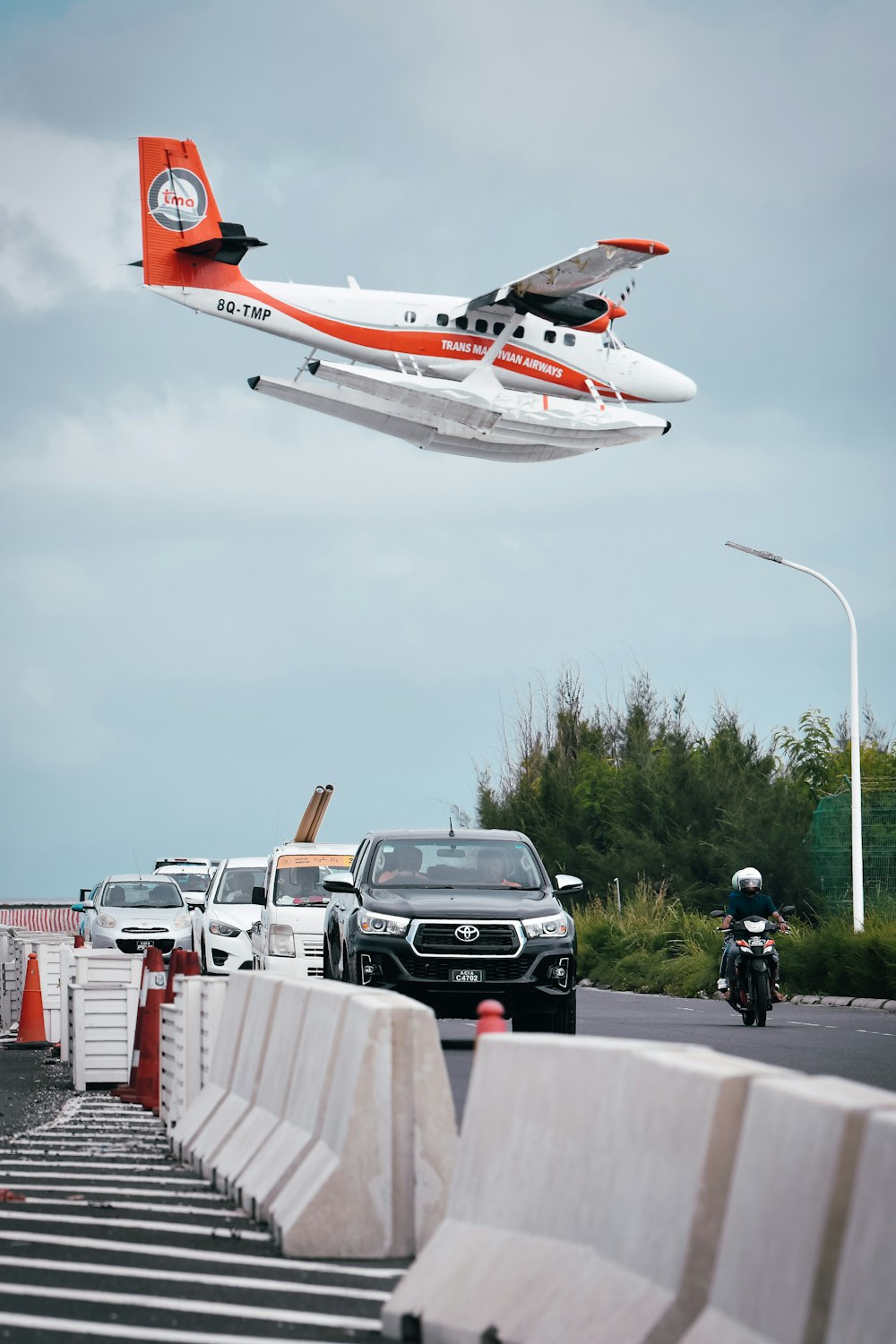 a plane is flying over a line of cars