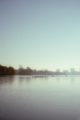 Early morning training session with rowers silhouetted against a misty lake.