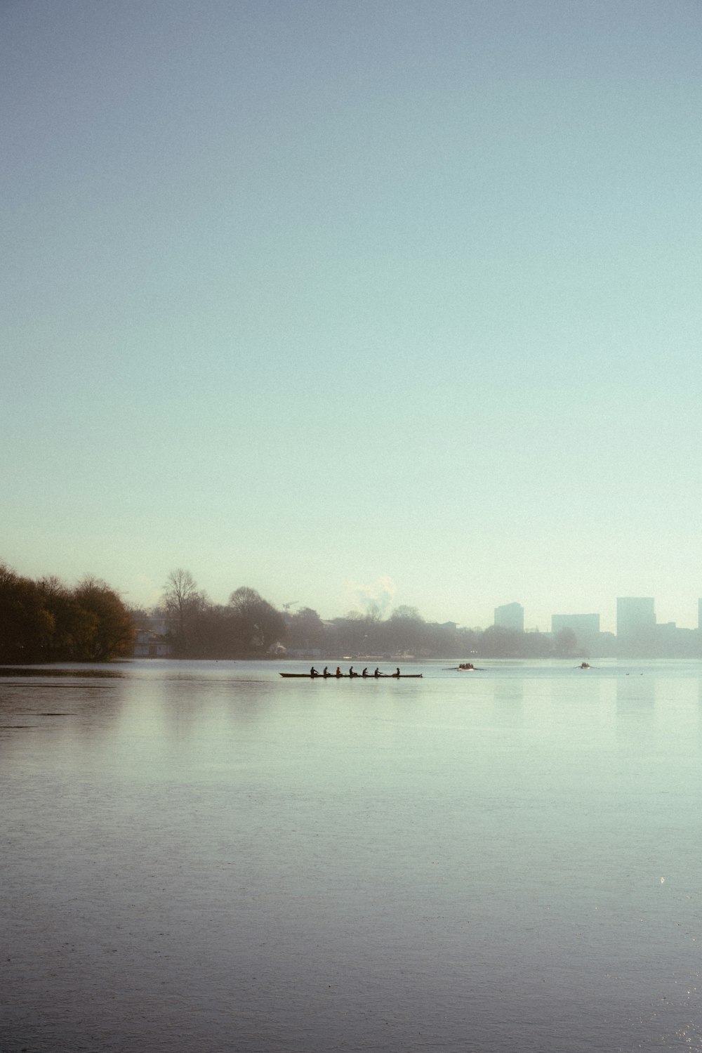 a group of people rowing a boat on a large body of water