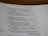 A close-up of an open book displaying text from a chapter, potentially from a religious scripture common in bibles. The visible text discusses themes of righteousness, wickedness, and justice.