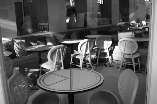 a black and white photo of tables and chairs