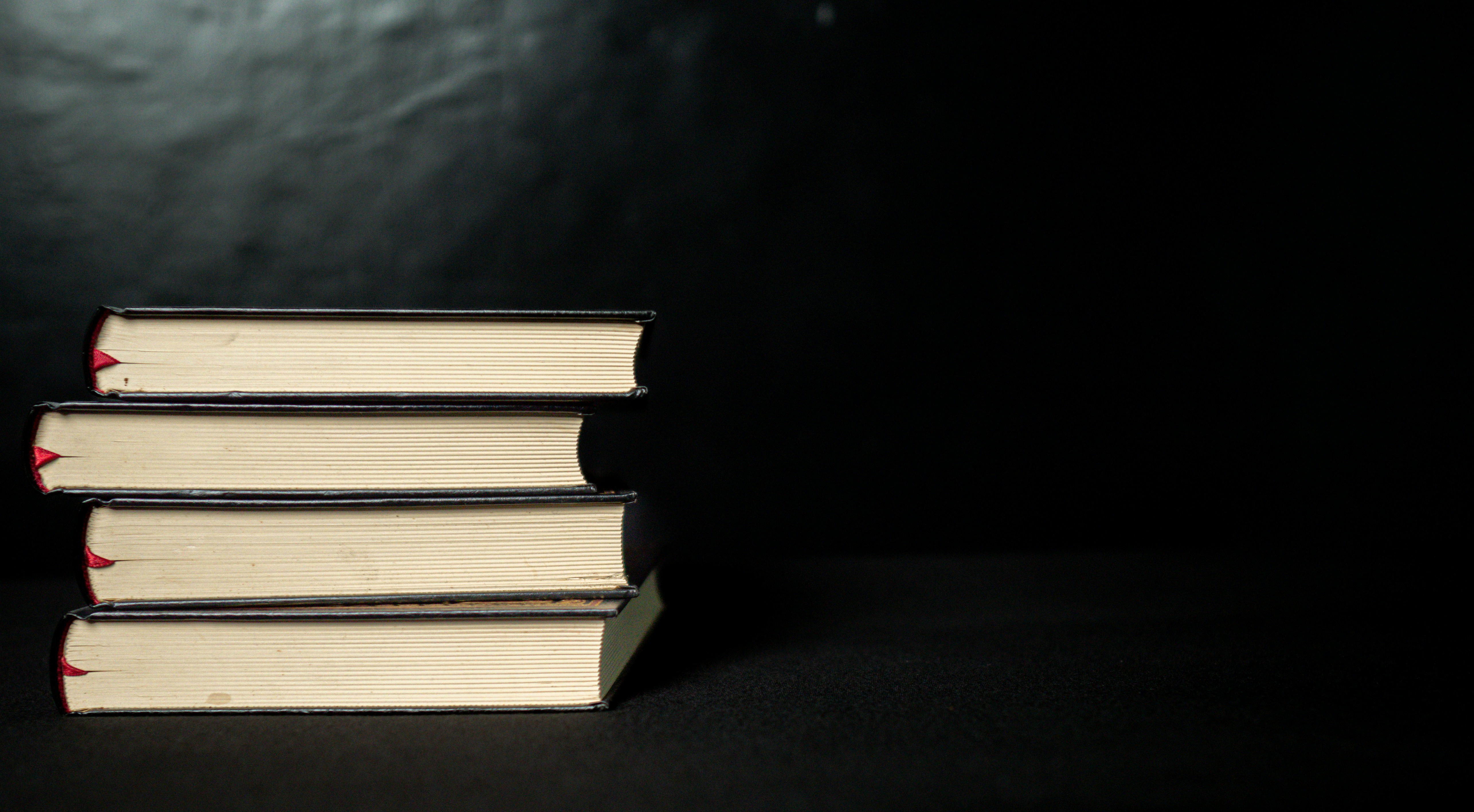 Four stacked books with black background