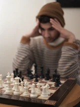 a man sitting at a table with a chess board