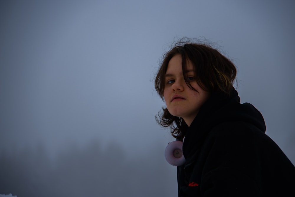 Une femme debout dans le brouillard, les yeux fermés