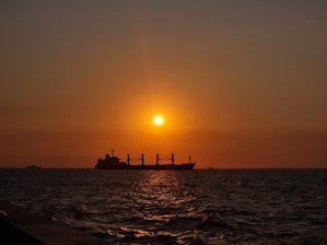 A sophisticated cargo ship at sunset, symbolizing global spice transport across oceans.