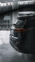 A sleek black SUV with a mirror-like finish parked in a garage.