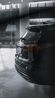 A sleek black SUV with a mirror-like finish parked in a garage.