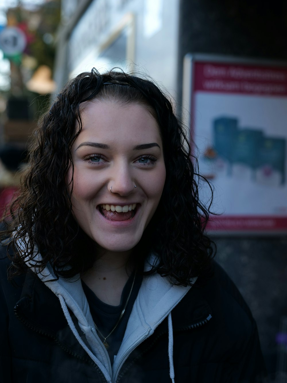 a woman with curly hair smiling at the camera