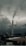 A tall industrial smokestack emits smoke against a backdrop of dark, cloudy skies. The surrounding area includes industrial buildings partially covered with snow. Distant hilltops are visible through the mist, enhancing the gloomy atmosphere.