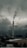 A tall industrial smokestack emits smoke against a backdrop of dark, cloudy skies. The surrounding area includes industrial buildings partially covered with snow. Distant hilltops are visible through the mist, enhancing the gloomy atmosphere.