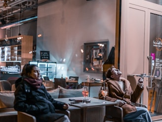 A cozy urban café scene where two people are chatting and laughing, suggesting a casual meetup nearby.