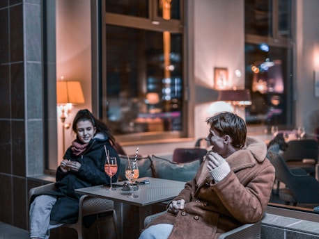 Two people sharing a warm conversation in a cozy, softly lit room.