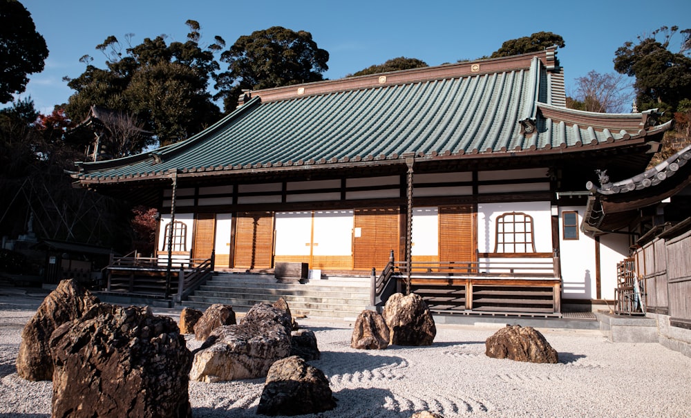 a building with a green roof surrounded by rocks