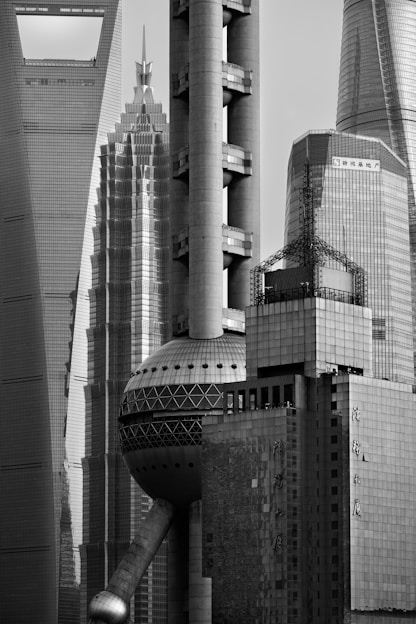 A sleek black-and-white architectural sketch overlaying a world map highlighting Milan, New Delhi, Rotterdam, and Accra.