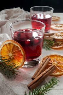 two glasses of mulled with cinnamon and orange slices