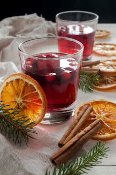two glasses of mulled with cinnamon and orange slices