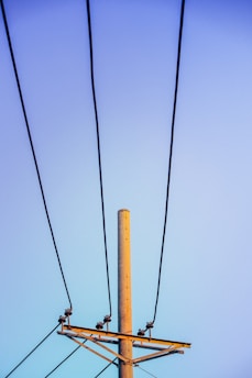 a telephone pole with a blue sky in the background