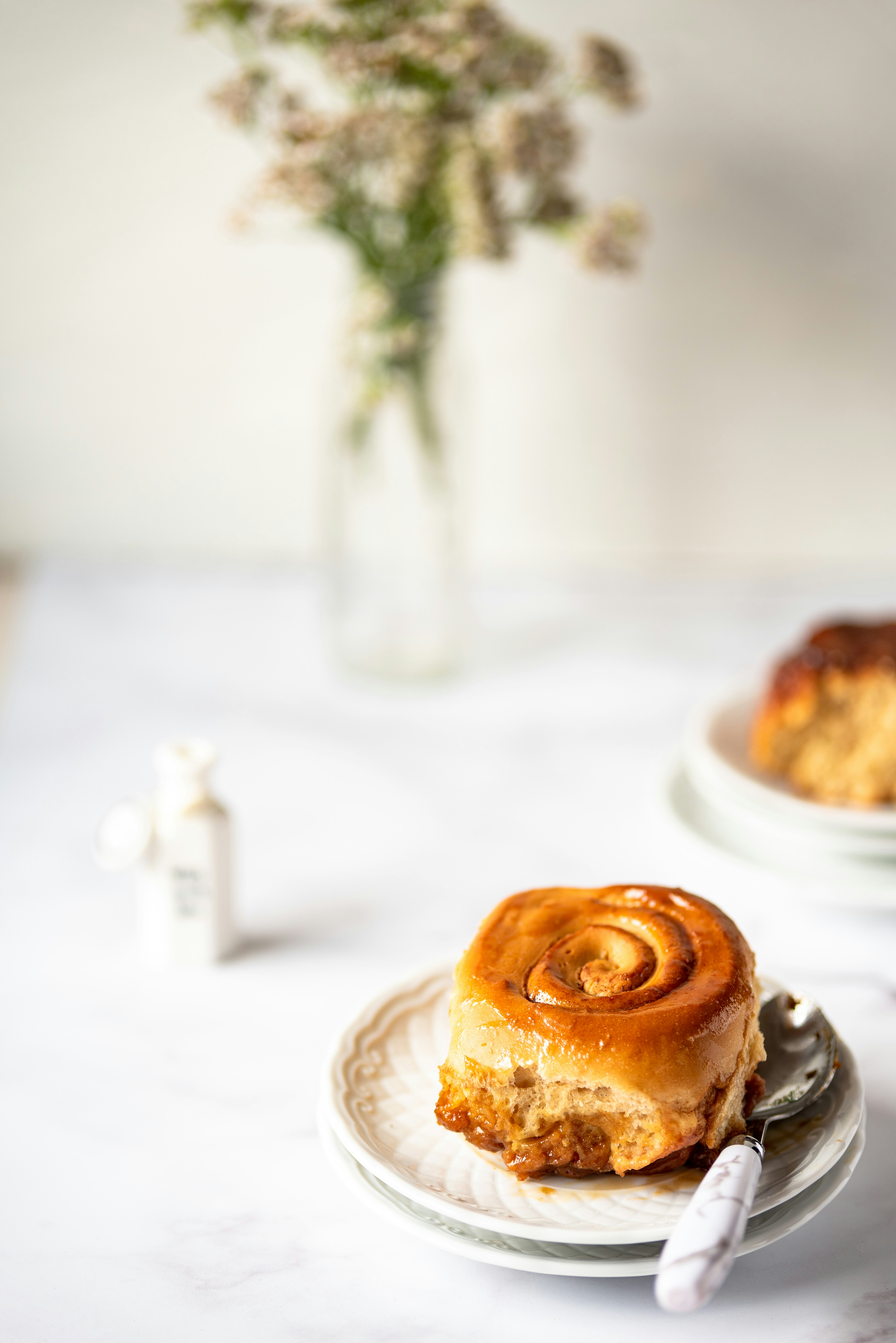 a plate with a piece of cinnamon roll on it