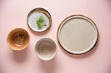 Small trinket dishes with subtle textures and warm colors, stacked gently together.