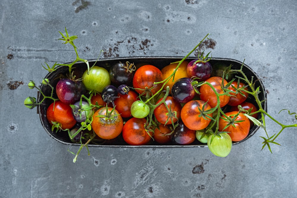 a container filled with lots of different types of tomatoes