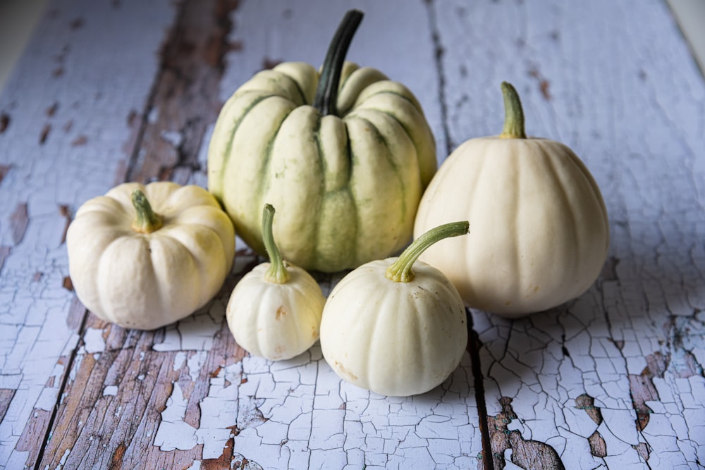 a group of pumpkins sitting on top of a wooden table