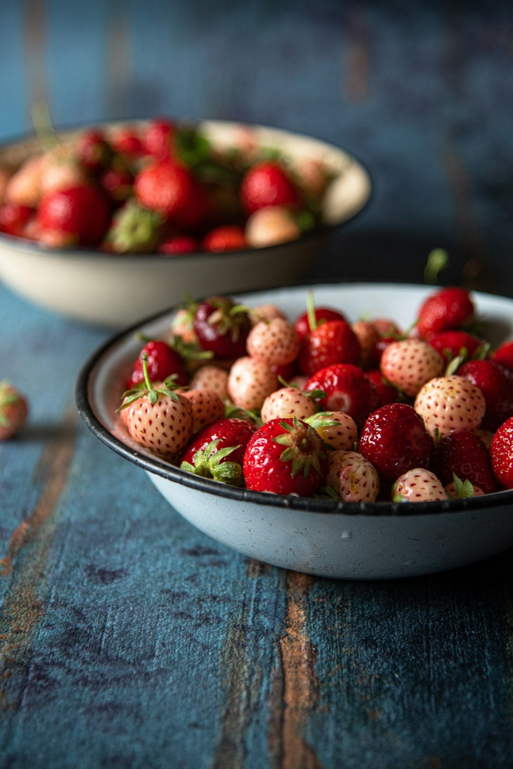 a couple of bowls of strawberries on a table
