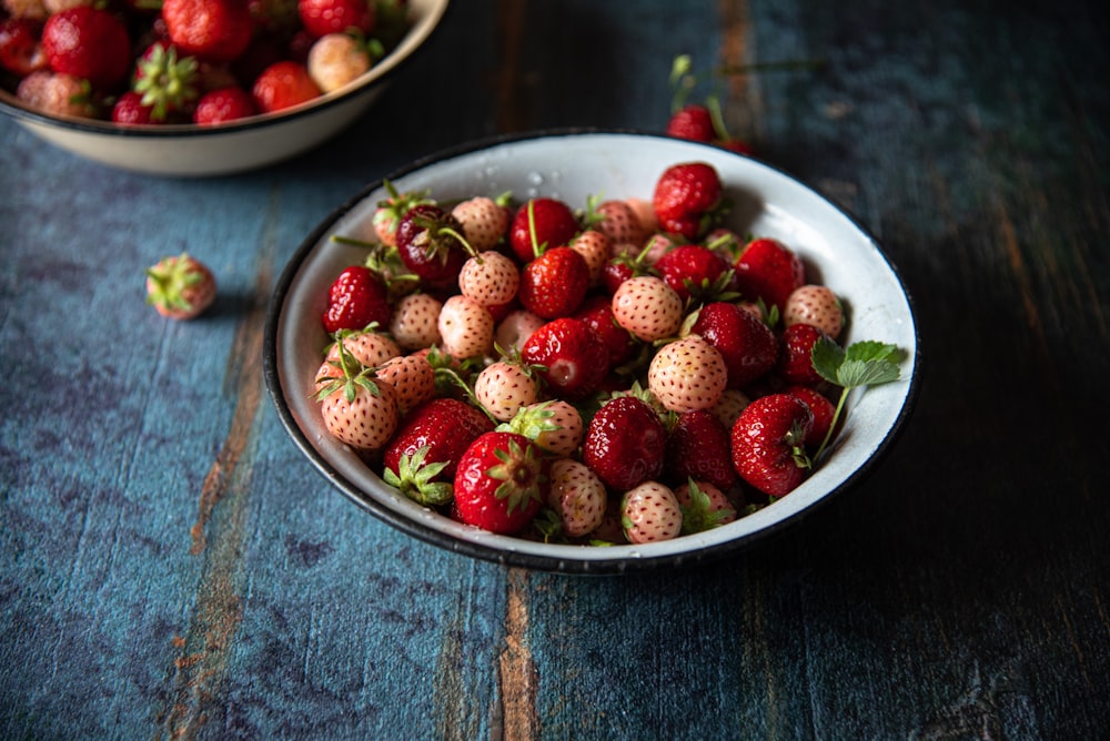 a bowl of strawberries sitting on a table