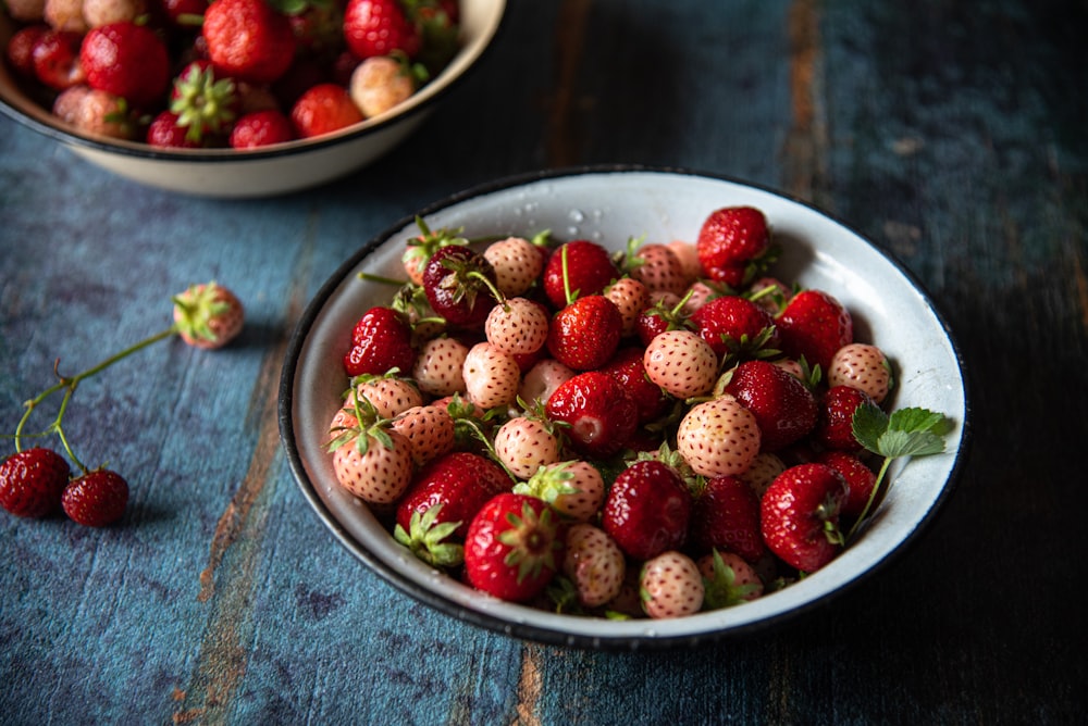 a bowl of strawberries on a wooden table