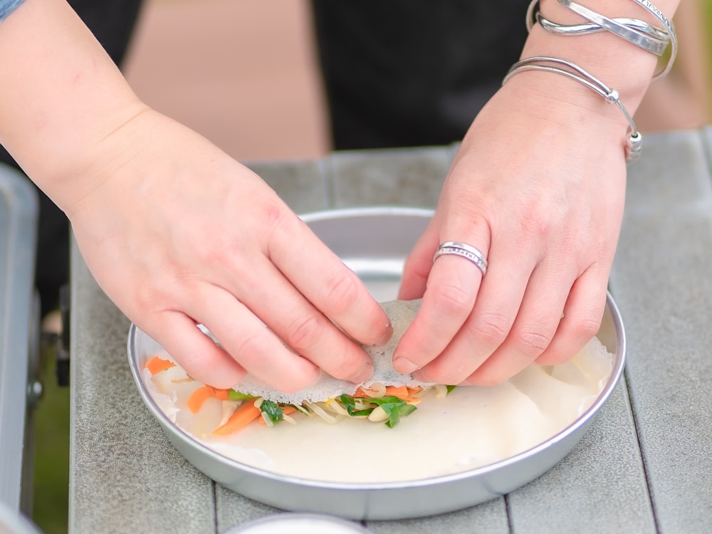 a woman is cutting up a sandwich on a plate