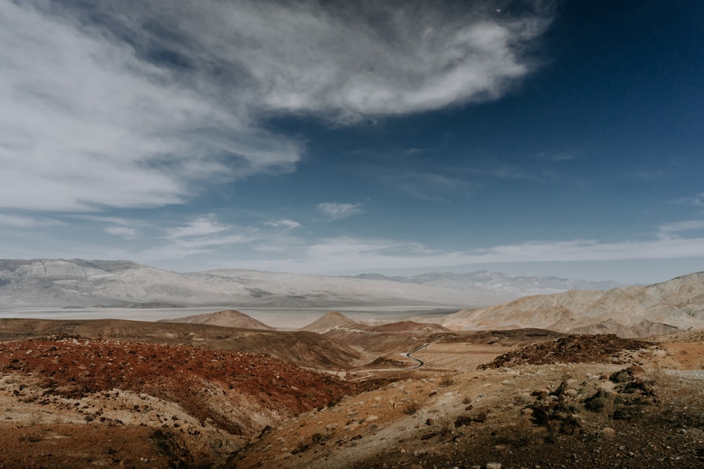 a view of a desert with mountains in the background