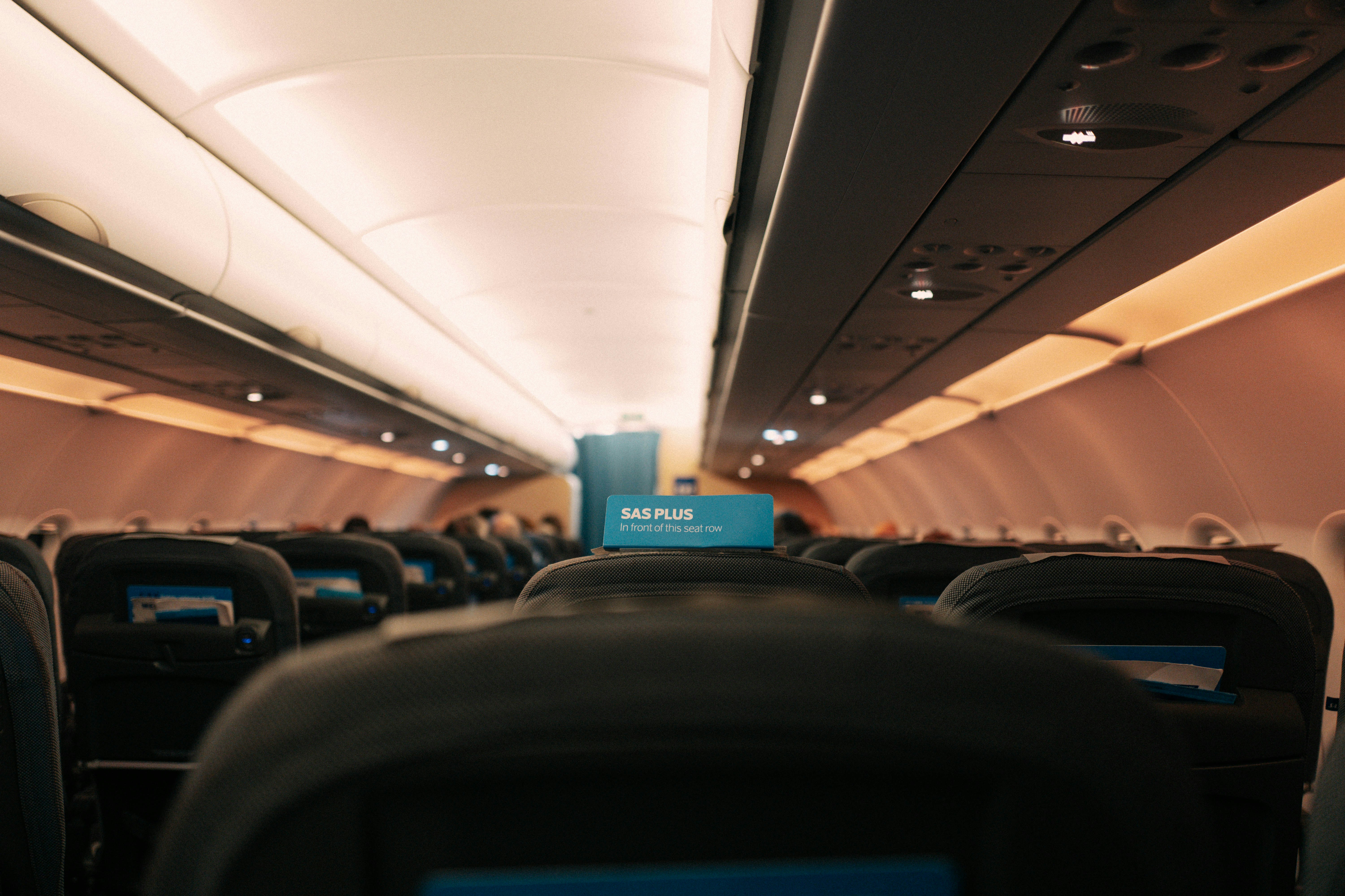 the inside of an airplane with the lights on, 