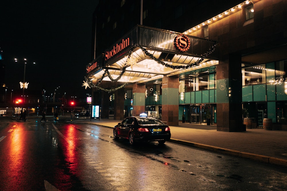 a car driving down a wet street at night